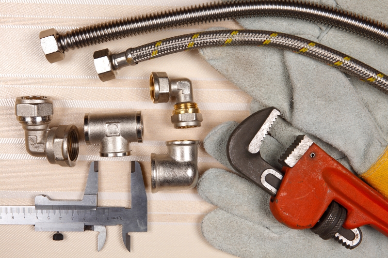 Plumber working on pipes in a Thames Ditton home